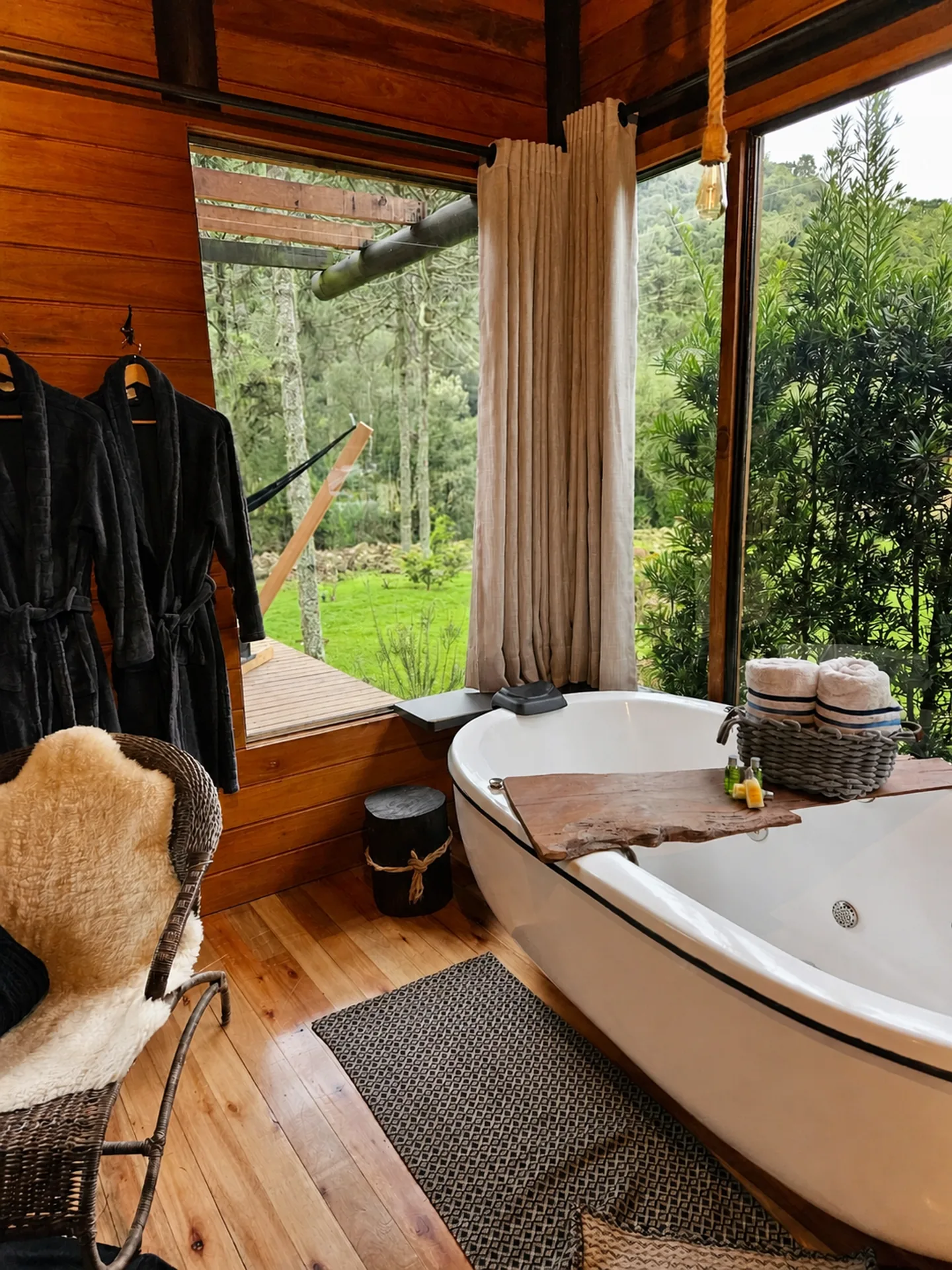 Banheira de hidromassagem da Cabana Araucária diante das janelas para a mata