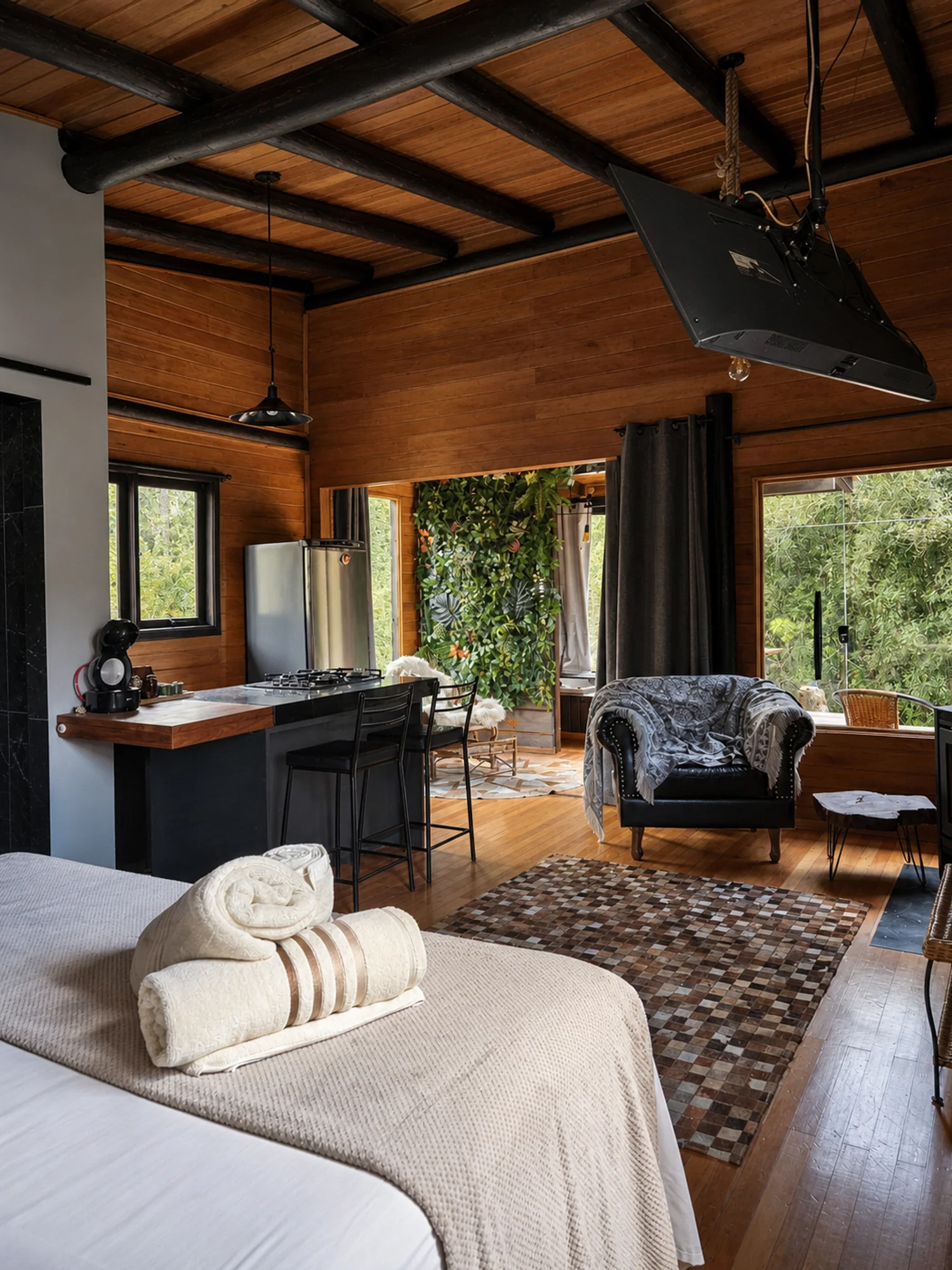 Interior integrado da Cabana do Rio com cama, cozinha e área de estar