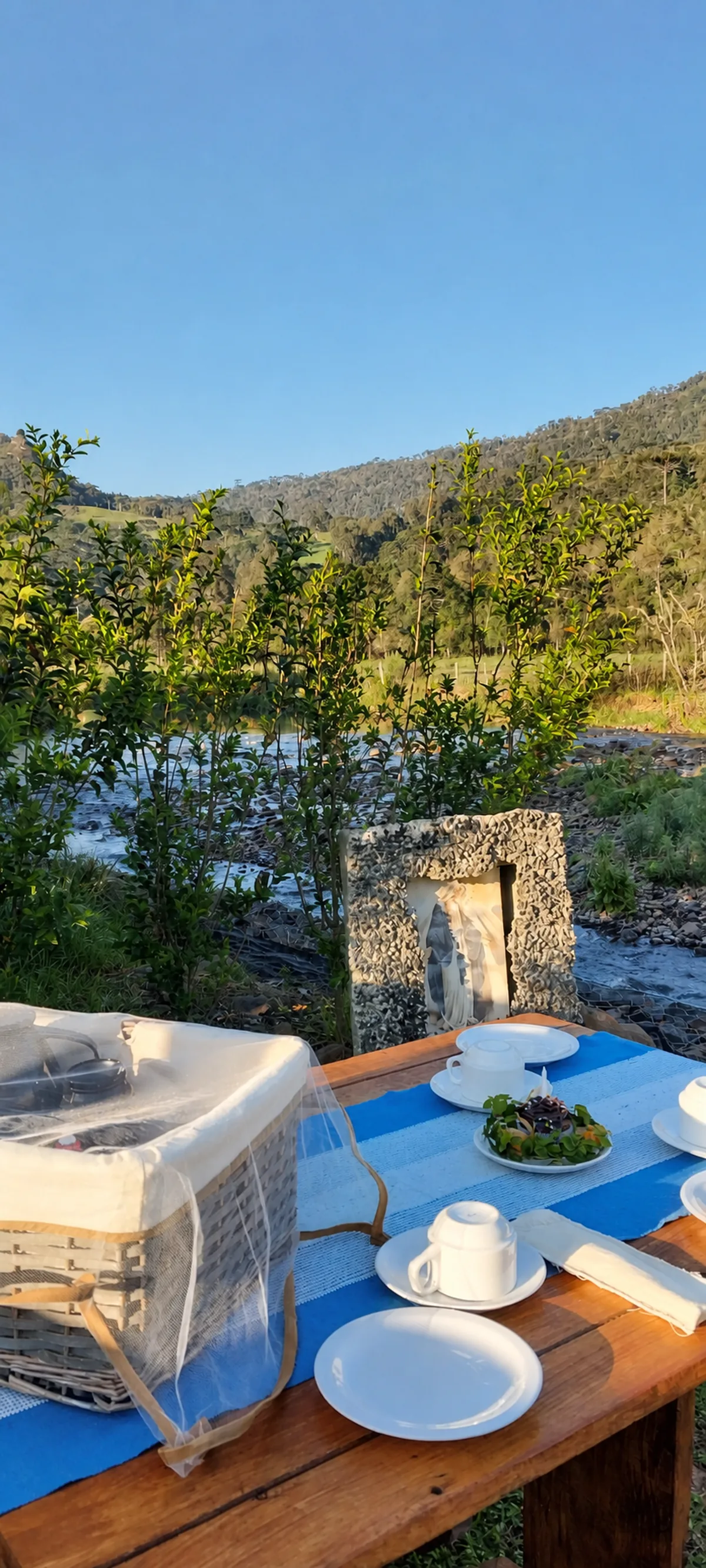 Mesa de café da manhã da Pousada Sentiero diante do rio e das montanhas